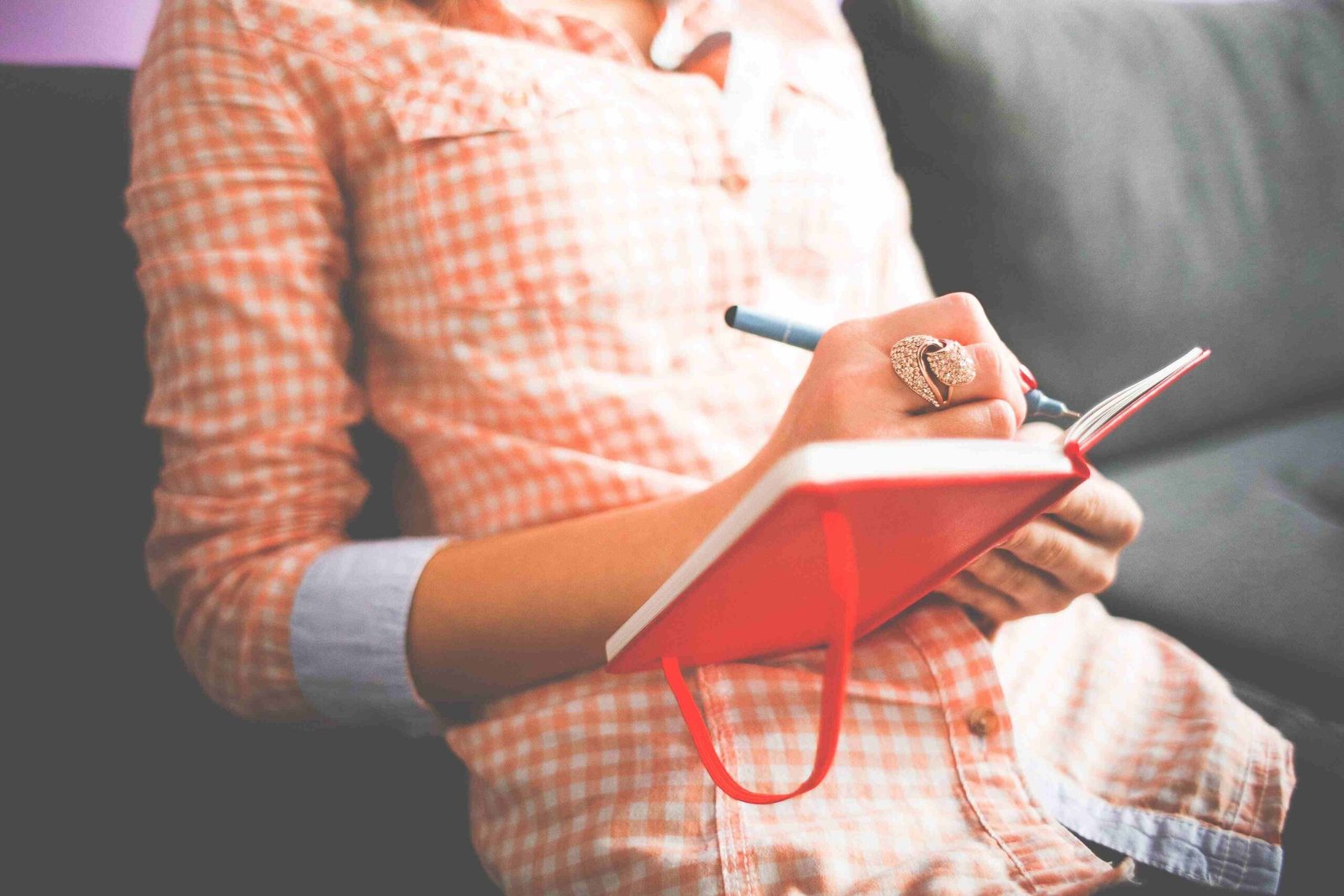 Person writing in a simple health journal to track daily wellness habits.